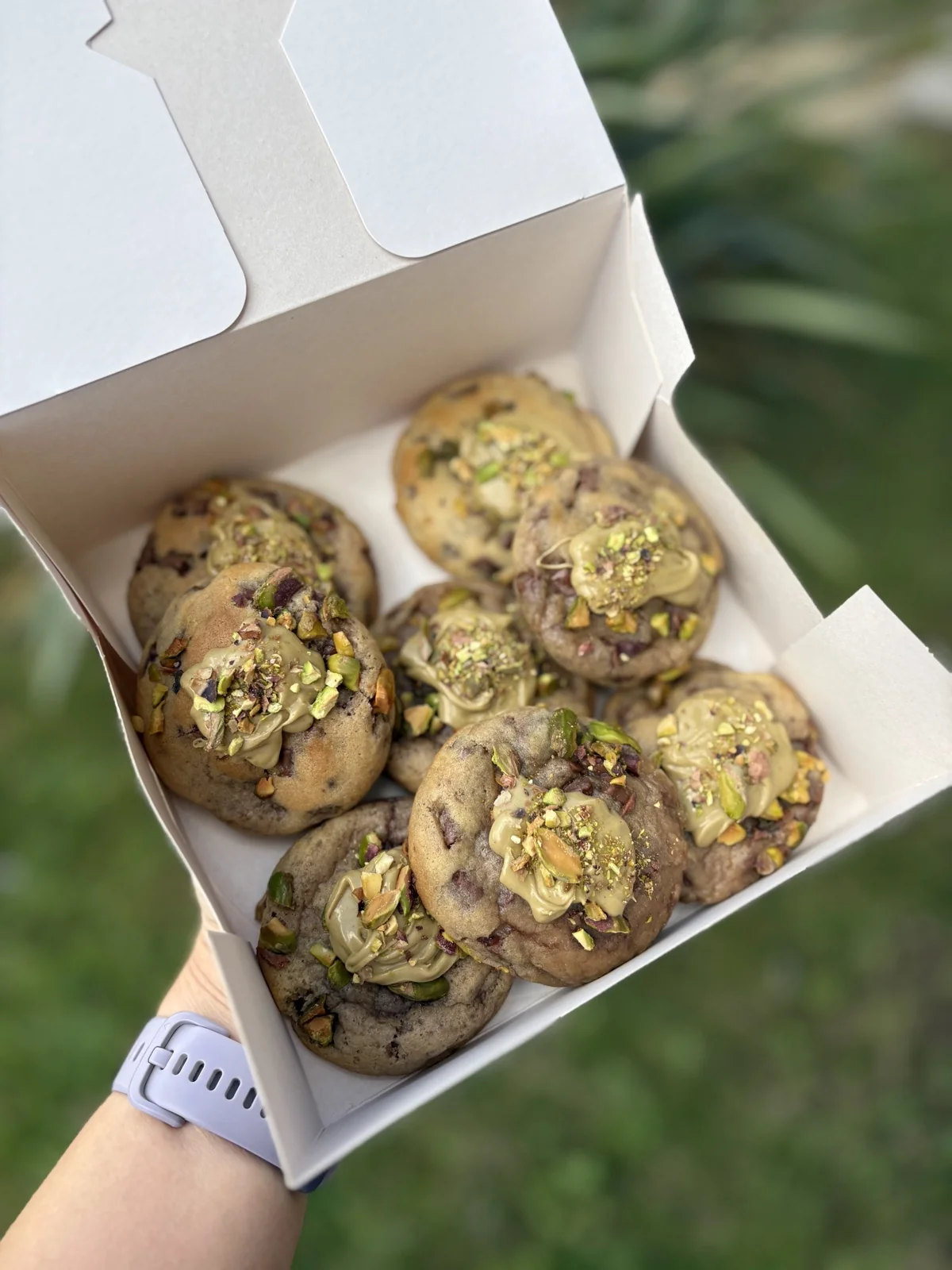 Box of pistachio cream topped cookies with chopped pistachios